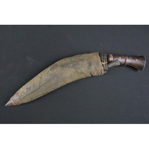 298 - An early to mid 20th century Kukri knife, steel blade with single groove fuller and sun face stamp, ... 