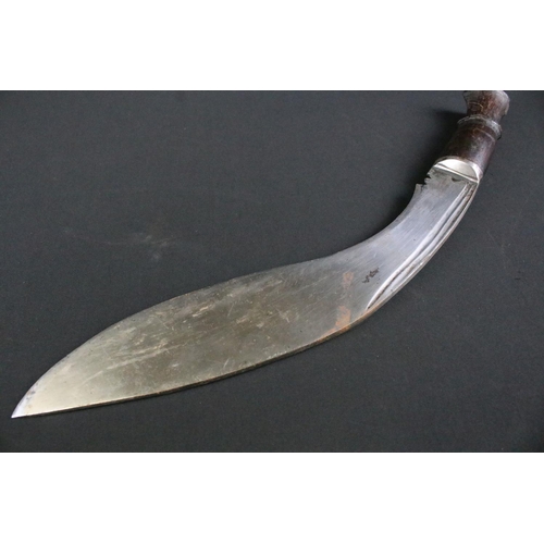 300 - A mid 20th century Kukri knife, twin groove fullered steel blade, turned wooden handle, blade measur... 