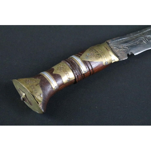 305 - A Nepalese tourist Kukri knife, highly decorative polished steel blade, turned wooden handle with br... 