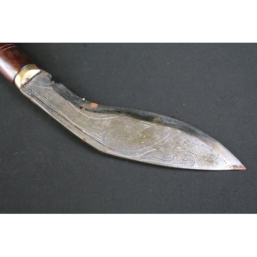 305 - A Nepalese tourist Kukri knife, highly decorative polished steel blade, turned wooden handle with br... 