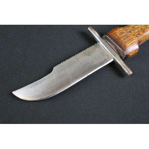 320 - A mid to late 20th century handmade fighting knife, steel blade on two piece wooden handle with matc... 