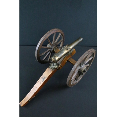 369 - A brass signal cannon mounted to wooden carriage with brass fittings, barrel length approx 26.5cm, o... 