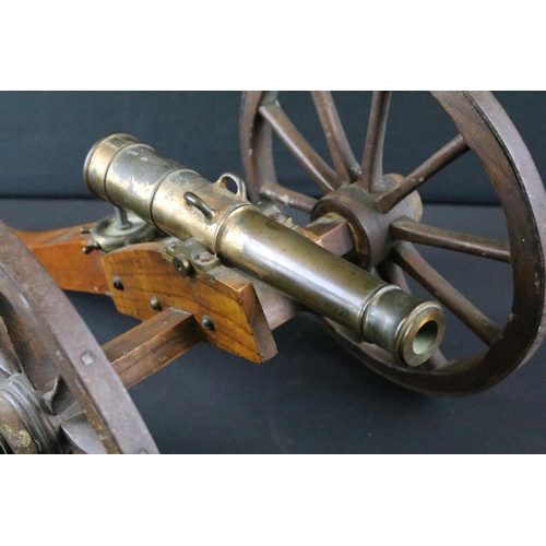 369 - A brass signal cannon mounted to wooden carriage with brass fittings, barrel length approx 26.5cm, o... 