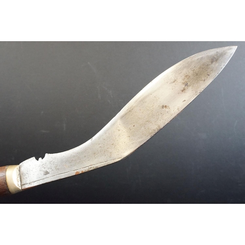 40 - A standard issue (BSI) Kukri knife, no markings to blade, wooden handle and white metal fittings, wi... 