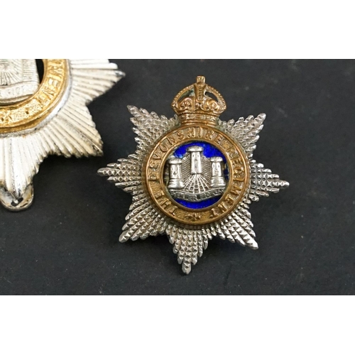 407 - A British The Devonshire Regiment officers cap badge with Queens Crown together with a pair of The D... 