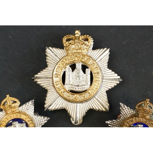 407 - A British The Devonshire Regiment officers cap badge with Queens Crown together with a pair of The D... 