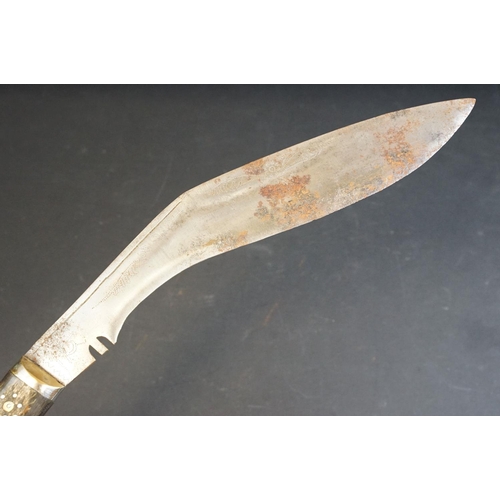 42 - A Kukuri knife with decorative dot engraved steel blade, inlayed wooden handle and leather covered w... 