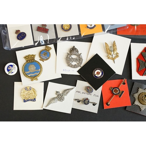 516 - A large collection of military badges to include cap badges, collar badges, military association bad... 