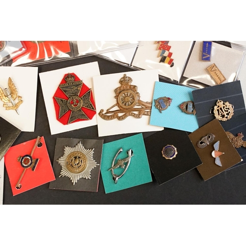 516 - A large collection of military badges to include cap badges, collar badges, military association bad... 