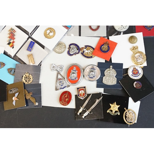 516 - A large collection of military badges to include cap badges, collar badges, military association bad... 