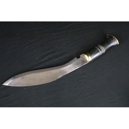 78 - A standard issue (BSI) Kukri knife, horn handle and brass fittings, with black leather covered woode... 