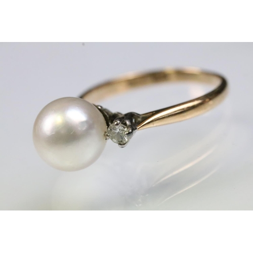 36 - 14ct gold, pearl and diamond ring. The ring being set with a central cultured pearl flanked by two r... 