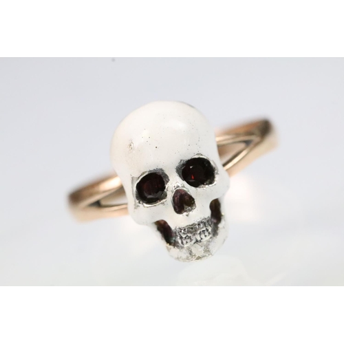 13 - 9ct gold and enamel skull ring. The ring being set with  a white enamelled skull to the head set wit... 