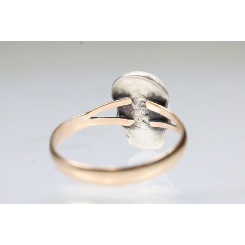 13 - 9ct gold and enamel skull ring. The ring being set with  a white enamelled skull to the head set wit... 