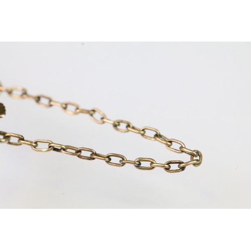14 - Early 20th Century 9ct gold bangle bracelet having a ruby and pearl set floral spray to the front wi... 