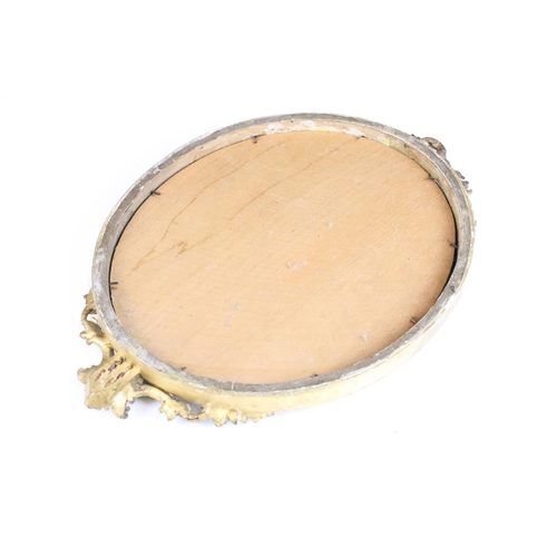 99 - Carved wood oval beveled gilded mirror with ribbon and bow detail, 41cm high x 28cm wide