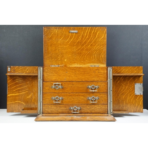 104 - Antique oak smokers cabinet with opening doors, pipe racks, three drawers and lift up lid with ashtr... 