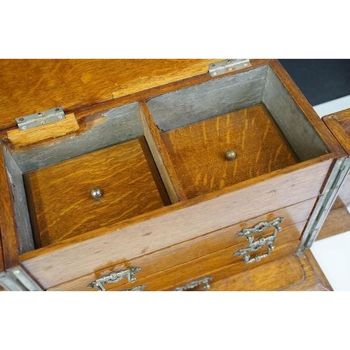 104 - Antique oak smokers cabinet with opening doors, pipe racks, three drawers and lift up lid with ashtr... 