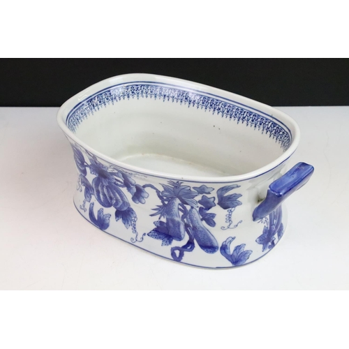 36 - Stoneware twin handled blue and white footbath decorated with fruits and foliage, 34cm long