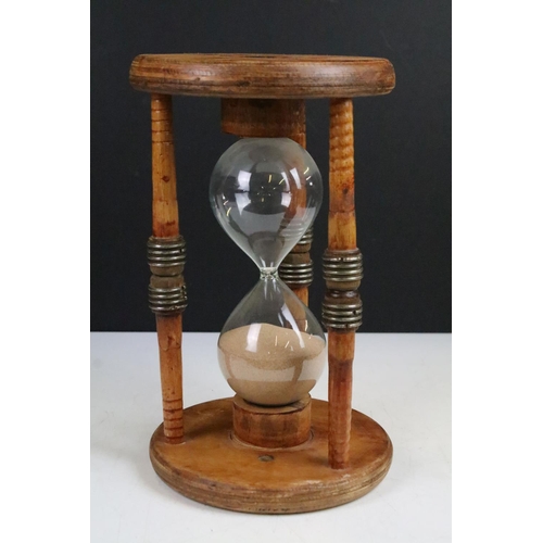 90 - Large glass egg timer, the frame formed from an old wooden weaving bobbin, 30cm high
