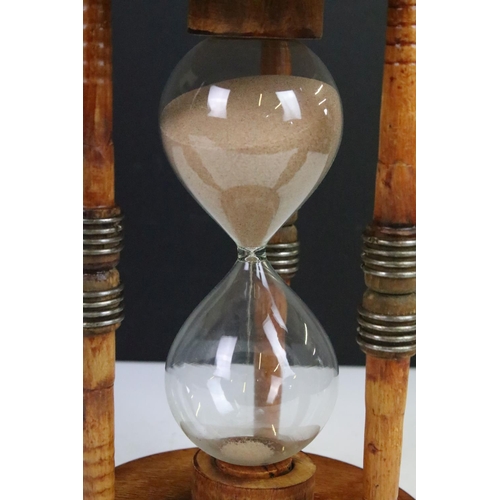 90 - Large glass egg timer, the frame formed from an old wooden weaving bobbin, 30cm high