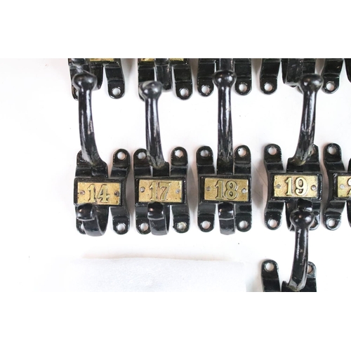 304 - Set of fifteen vintage cast iron coat hooks with gold coloured numbering