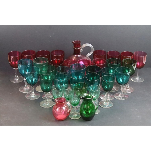 59 - Large selection of green (20) and cranberry (12) clear stemmed glasses with small pouring jugs and c... 