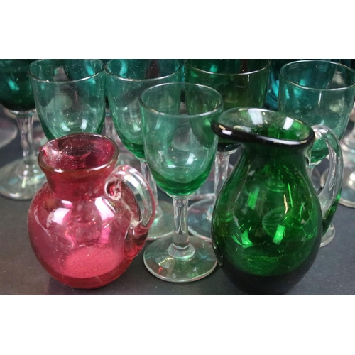 59 - Large selection of green (20) and cranberry (12) clear stemmed glasses with small pouring jugs and c... 