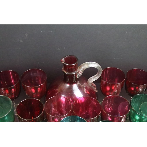 59 - Large selection of green (20) and cranberry (12) clear stemmed glasses with small pouring jugs and c... 