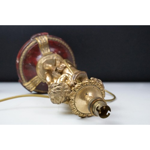 146 - Gilt metal table lamp modelled as two putto, with a red marble base with gilt metal mounts (detached... 