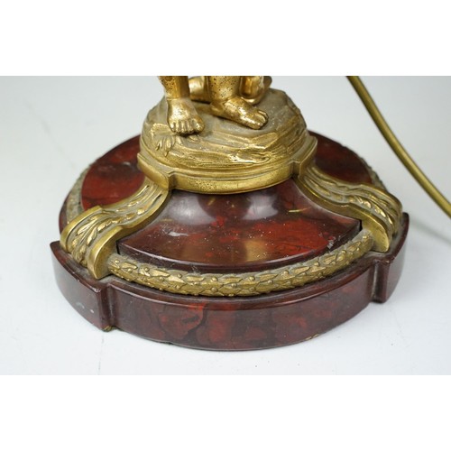 146 - Gilt metal table lamp modelled as two putto, with a red marble base with gilt metal mounts (detached... 