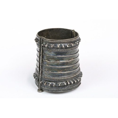 197 - A white metal ethnic / tribal cuff bangle together with a small cast metal tribal figure.