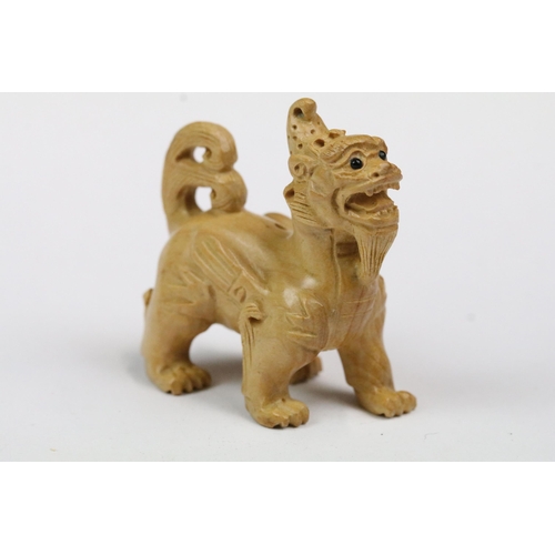 216 - Four wood netsuke figures to include signed seated happy buddha, dog, dragon and foliage/fruit carvi... 