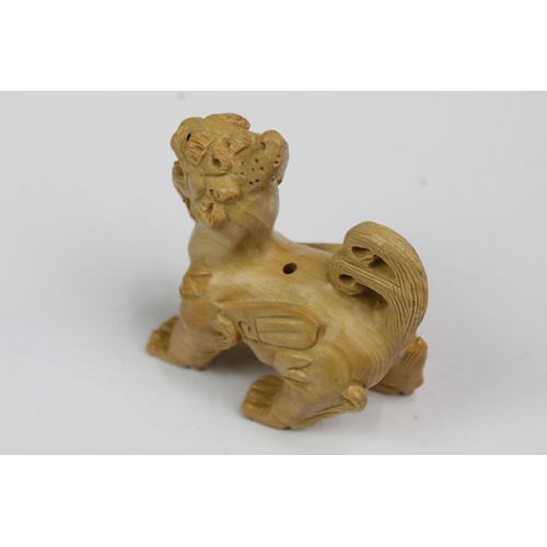 216 - Four wood netsuke figures to include signed seated happy buddha, dog, dragon and foliage/fruit carvi... 