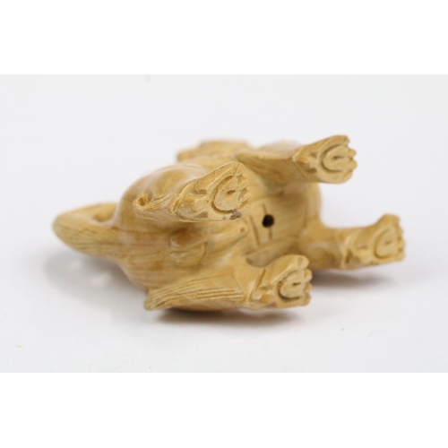 216 - Four wood netsuke figures to include signed seated happy buddha, dog, dragon and foliage/fruit carvi... 