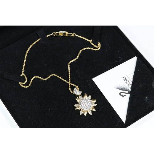 230 - A Swarovski Jeweler's collection gold tone necklace with sun and crescent moon pendant, in fitted di... 