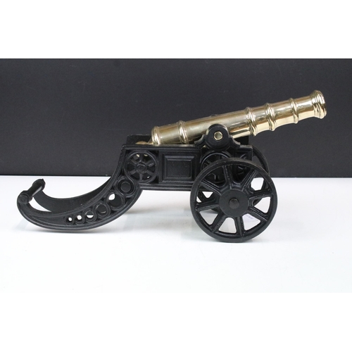 371 - Brass and cast iron model tabletop canon with moveable wheels, H 20cm, W 47cm, D 13.5cm