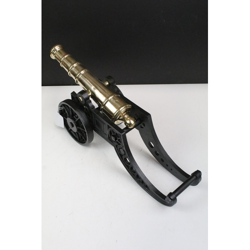 371 - Brass and cast iron model tabletop canon with moveable wheels, H 20cm, W 47cm, D 13.5cm