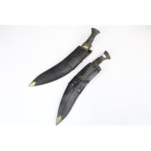 234 - A collection of three Kukri knives, all in leather scabbards and complete with tool / small knives.