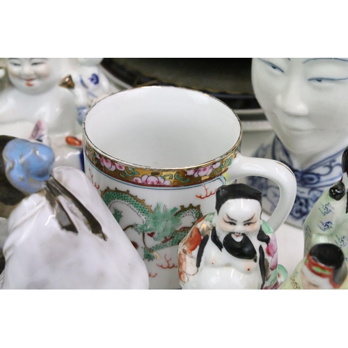 103 - Large assortment of Oriental ceramics to include bowls, plates, ornament figurines, clay mud man orn... 