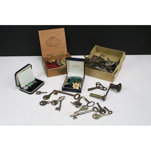 304 - A small group of mixed collectables to include military badges, keys and driving medal.