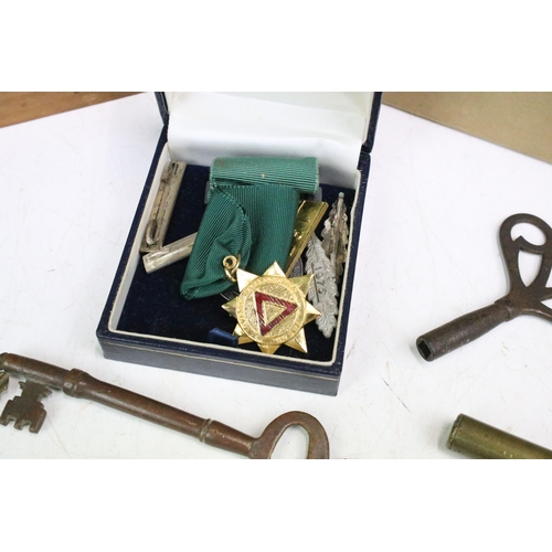 304 - A small group of mixed collectables to include military badges, keys and driving medal.