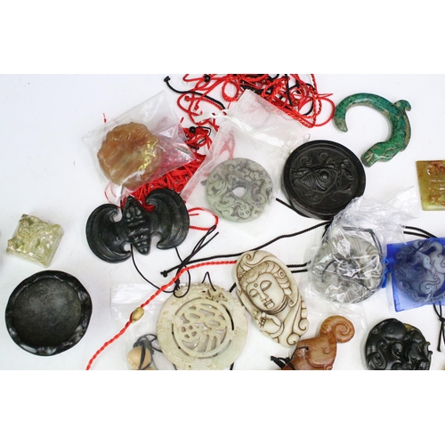 309 - A collection of Chinese carved stone ornaments and amulets of various shapes and size.