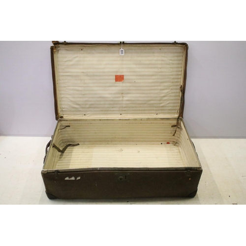 653 - Large vintage suitcase with travel stickers and side handles, latch and lock closures, leather corne... 