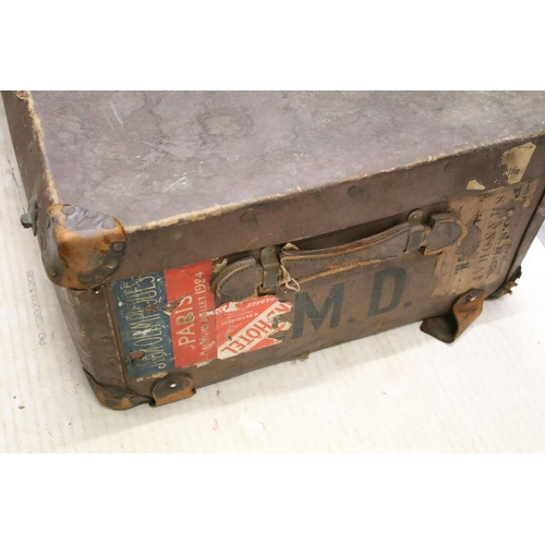 653 - Large vintage suitcase with travel stickers and side handles, latch and lock closures, leather corne... 