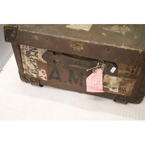 653 - Large vintage suitcase with travel stickers and side handles, latch and lock closures, leather corne... 