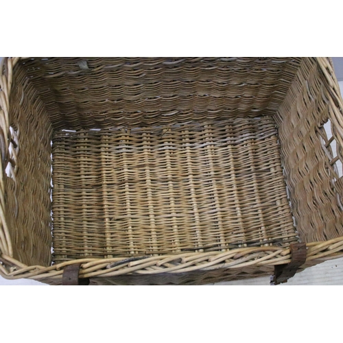 654 - Early 20th century wicker hamper with liftable lid and strap closure, H 48cm W 80cm