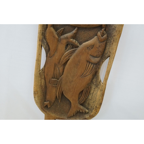 127 - African tribal carved chair back featuring a fisherman and fish to central panel. Measures 134cm tal... 