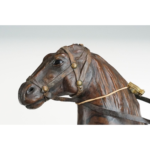 139 - Two 19th century Liberty style leather horse sculptures with saddles