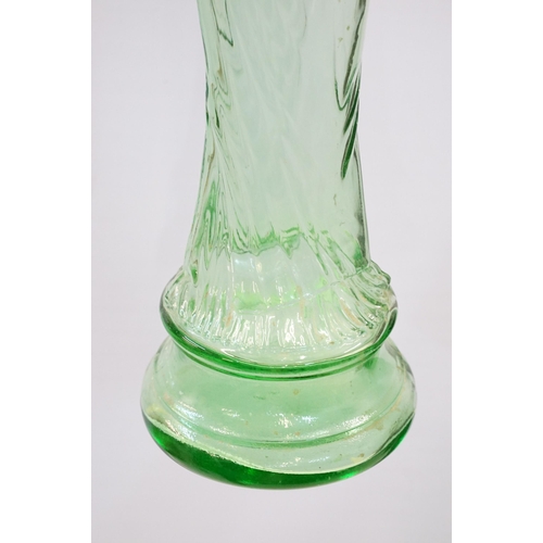 147 - Novelty green glass genie bottle in the form of a woman holding a bottle, 91.5cm high